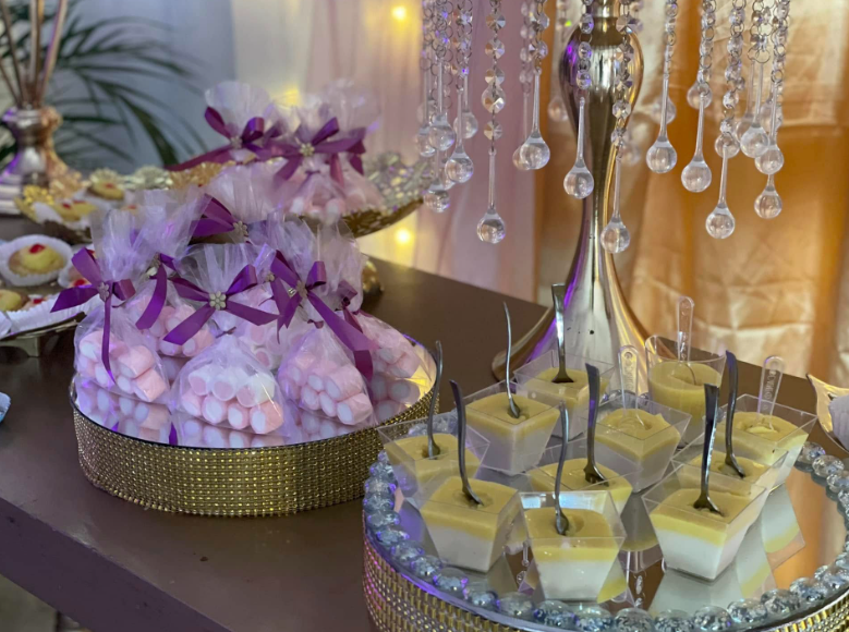Bolsas de dulces con lazos y postres individuales sobre bandejas de cristal