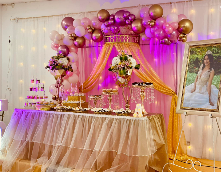 Mesa de dulces con falda de tul dorado y retrato de la quinceañera
